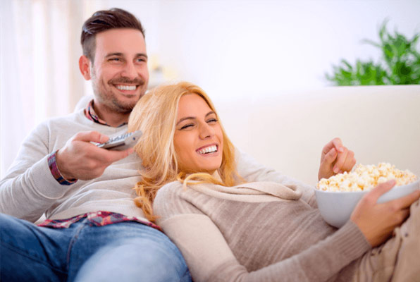 young couple watching an on-demand movie on DISH